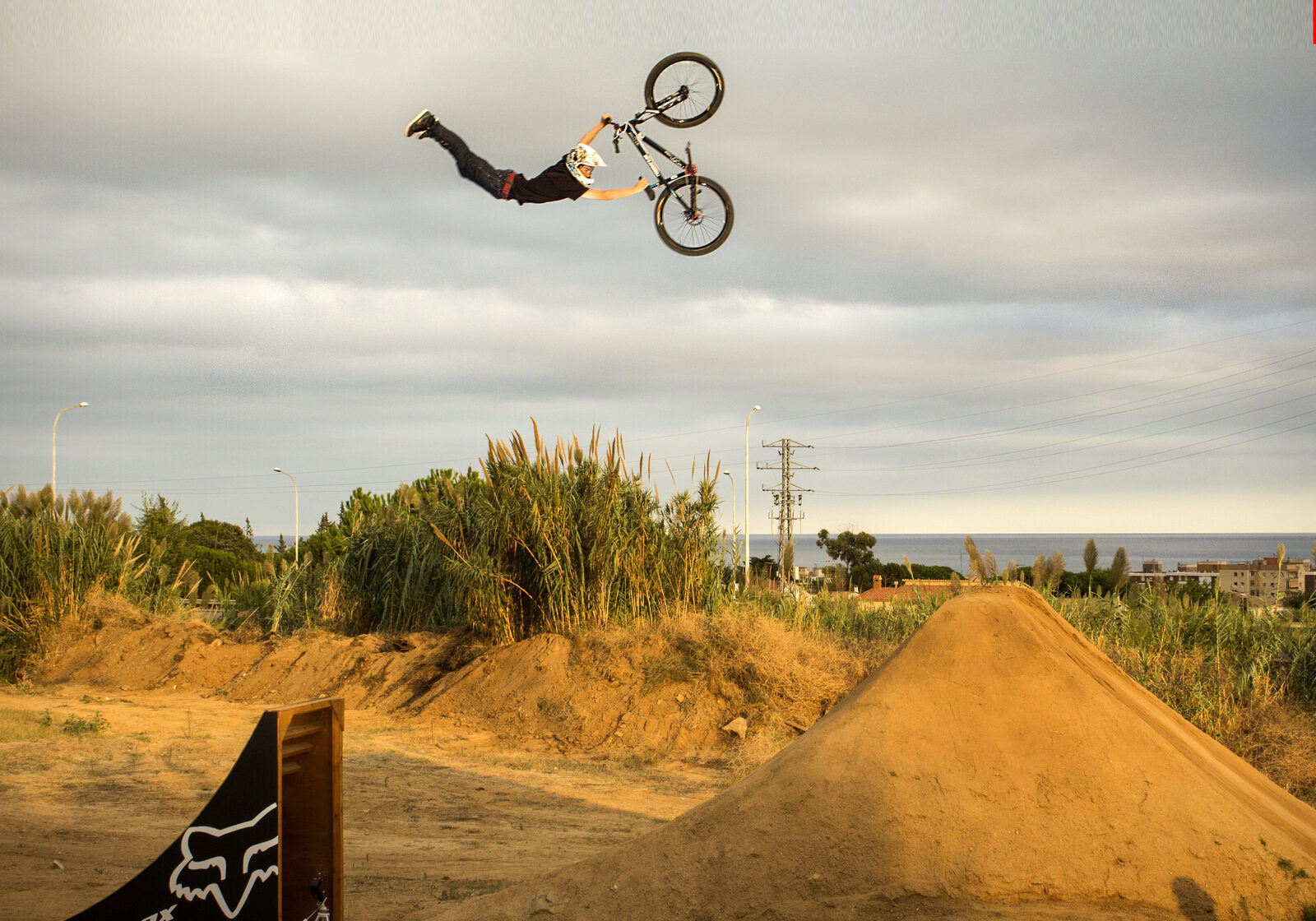 A rider high above a jump against an open sky