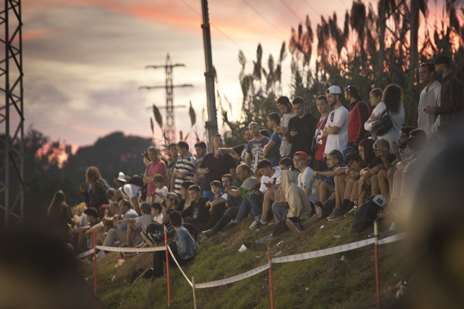 A crowd watching Happy Ride Weekend under floodlights at night