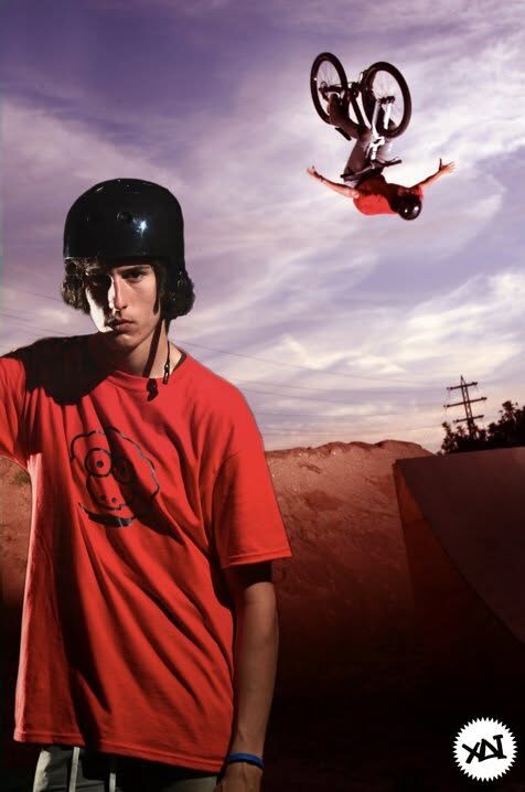 Campaign frame: a rider in a red XAI shirt in the foreground, another rider mid-air above him