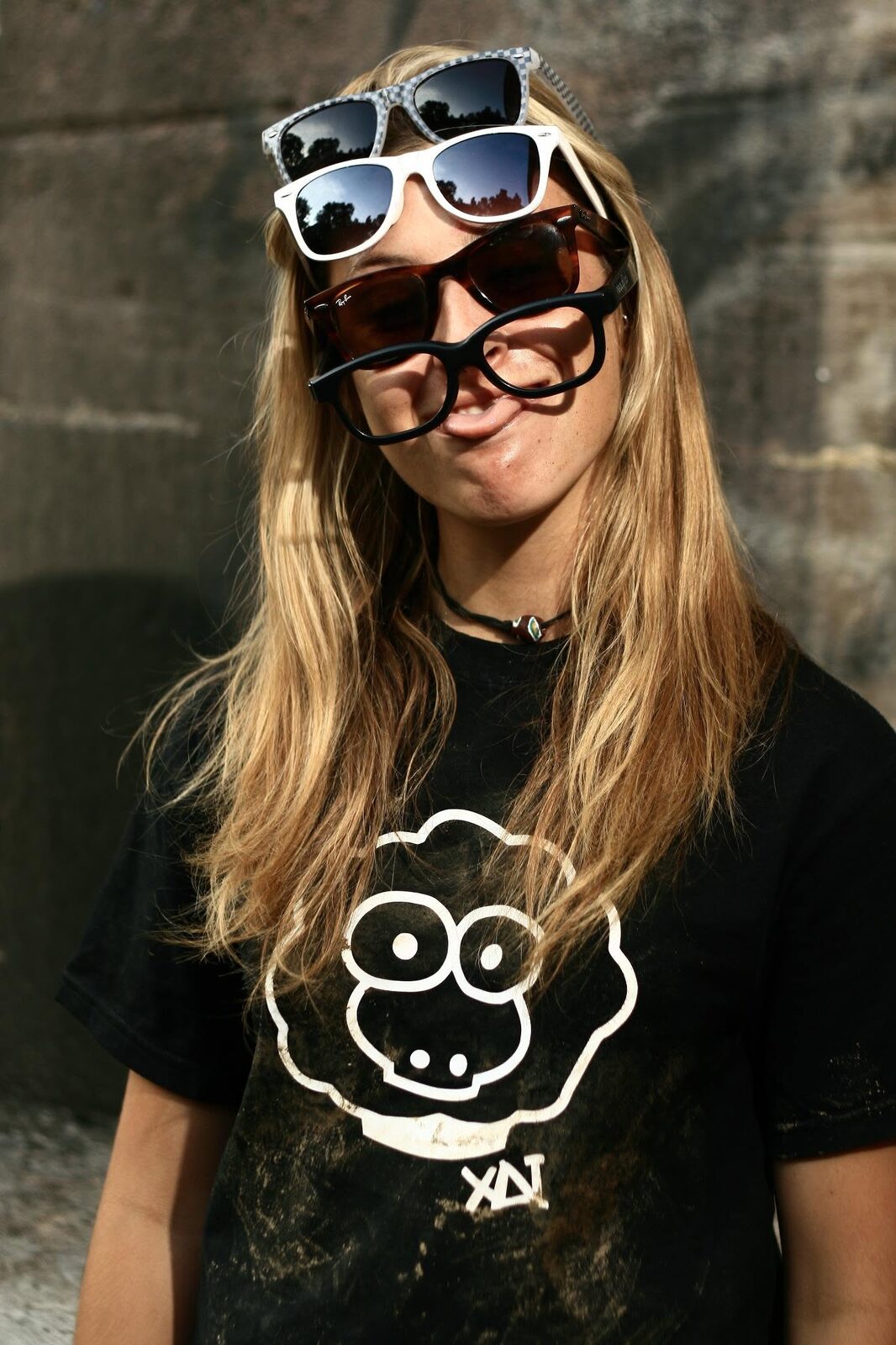 A girl wearing a black XAI t-shirt with the white sheep logo