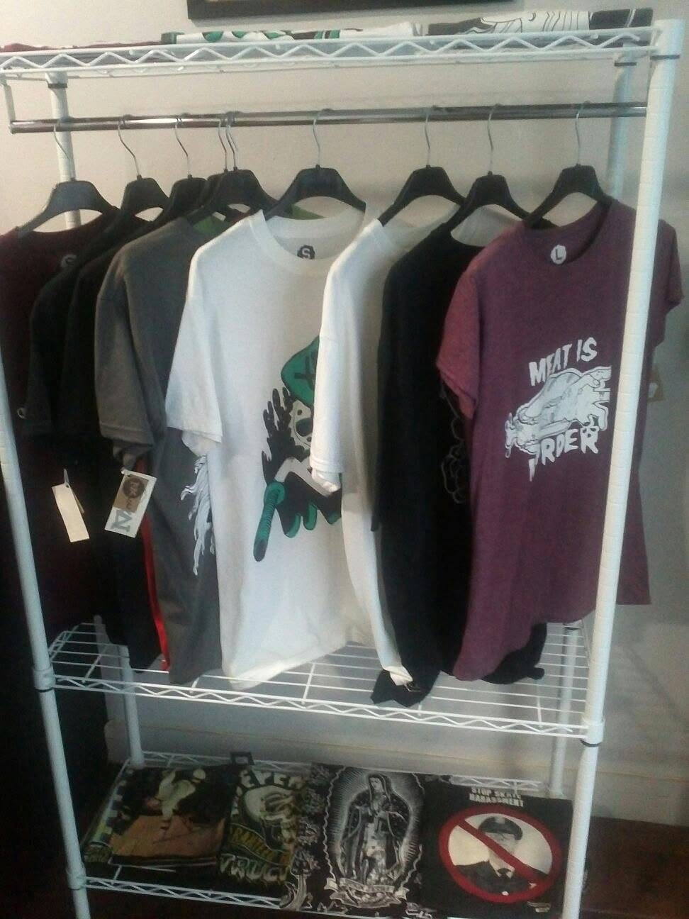 A retail rail of XAI t-shirts on hangers with swing tags