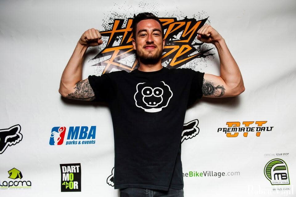 A rider in a XAI sheep t-shirt posing in front of the event backdrop