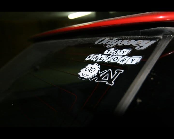 A car rear window with XAI and Odyssey stickers