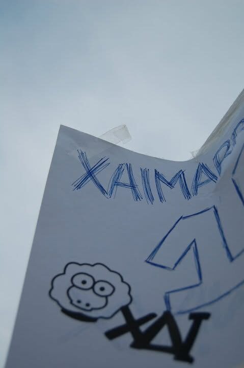 A hand-drawn XAI market sign with the sheep and wordmark