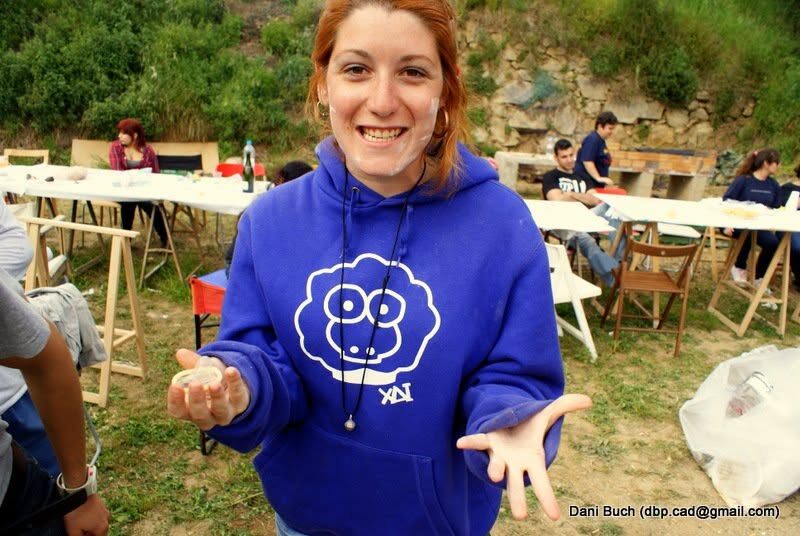A girl in a blue XAI sheep hoodie laughing at an outdoor event