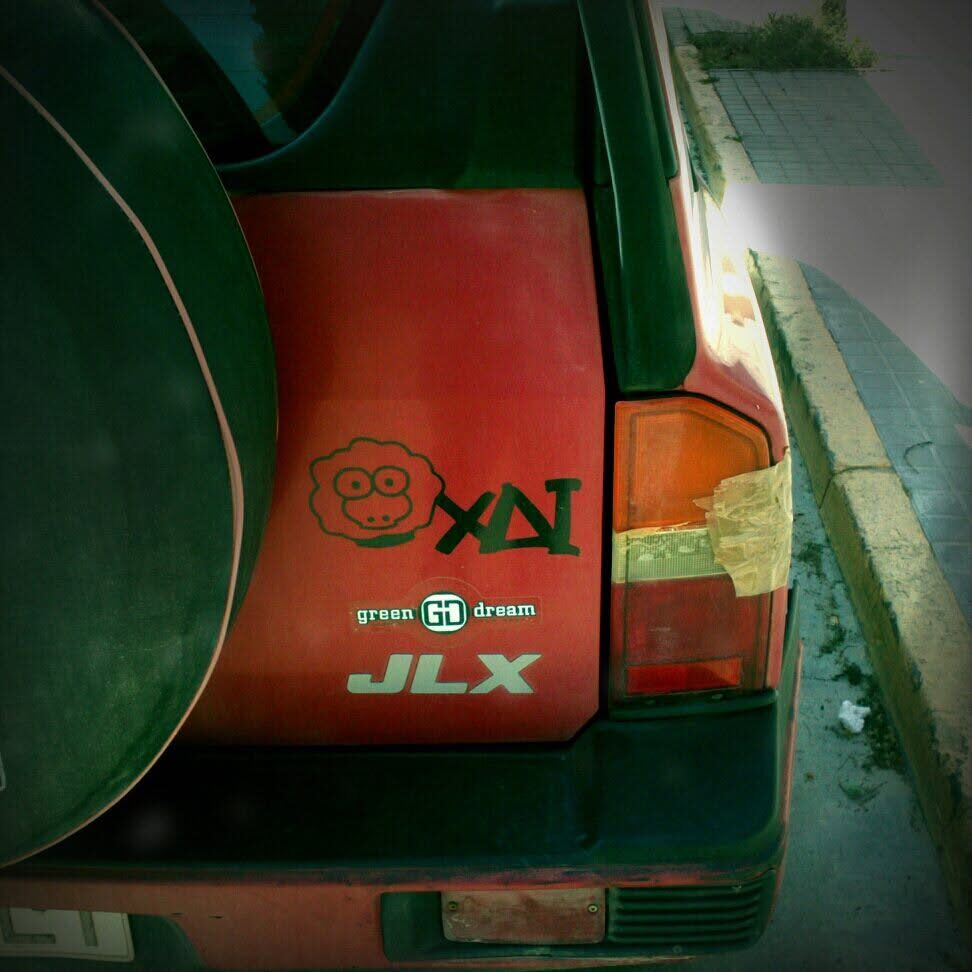 A green van with the XAI sheep and wordmark painted on the back